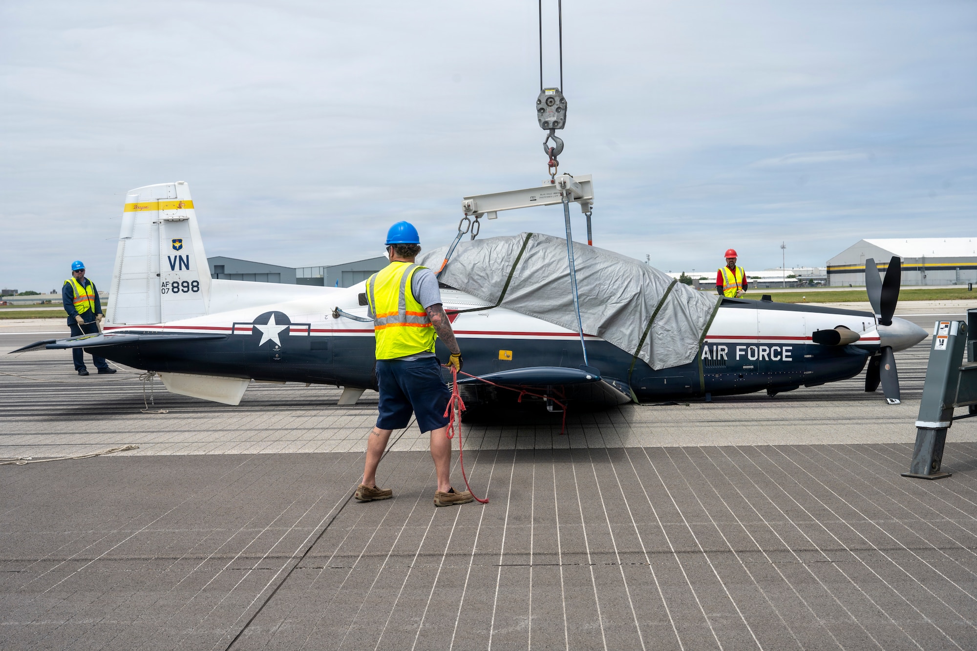 Members of Vance Air Force Base, Oklahoma's Crash Damaged Disabled Aircraft Recovery team remove a T-6A Texan II from McConnell Air Force Base, Kansas's flightline May 20,2026. The T-6A, from Vance AFB, performed an emergency belly-landing due to a landing gear malfunction, avoiding injury to both aircrew members. (U.S. Air Force photo by Airman 1st Class Tavian Sims)