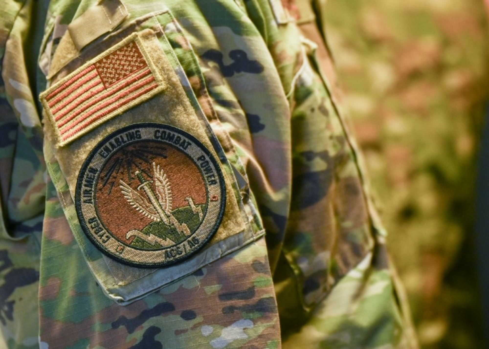U.S. Air Force Brig. Gen. Jeffrey Phillips, right, Air Combat Command director of Cyberspace Operations and Warfighting Communications (ACC/A6), wears an A6 patch during the Raptor Town Tactical Communications Demonstration at Joint Base Langley-Eustis, Virginia, May 7, 2026. The patch symbolizes their dedication to secure communication and cyber systems in support of operations in austere environments.