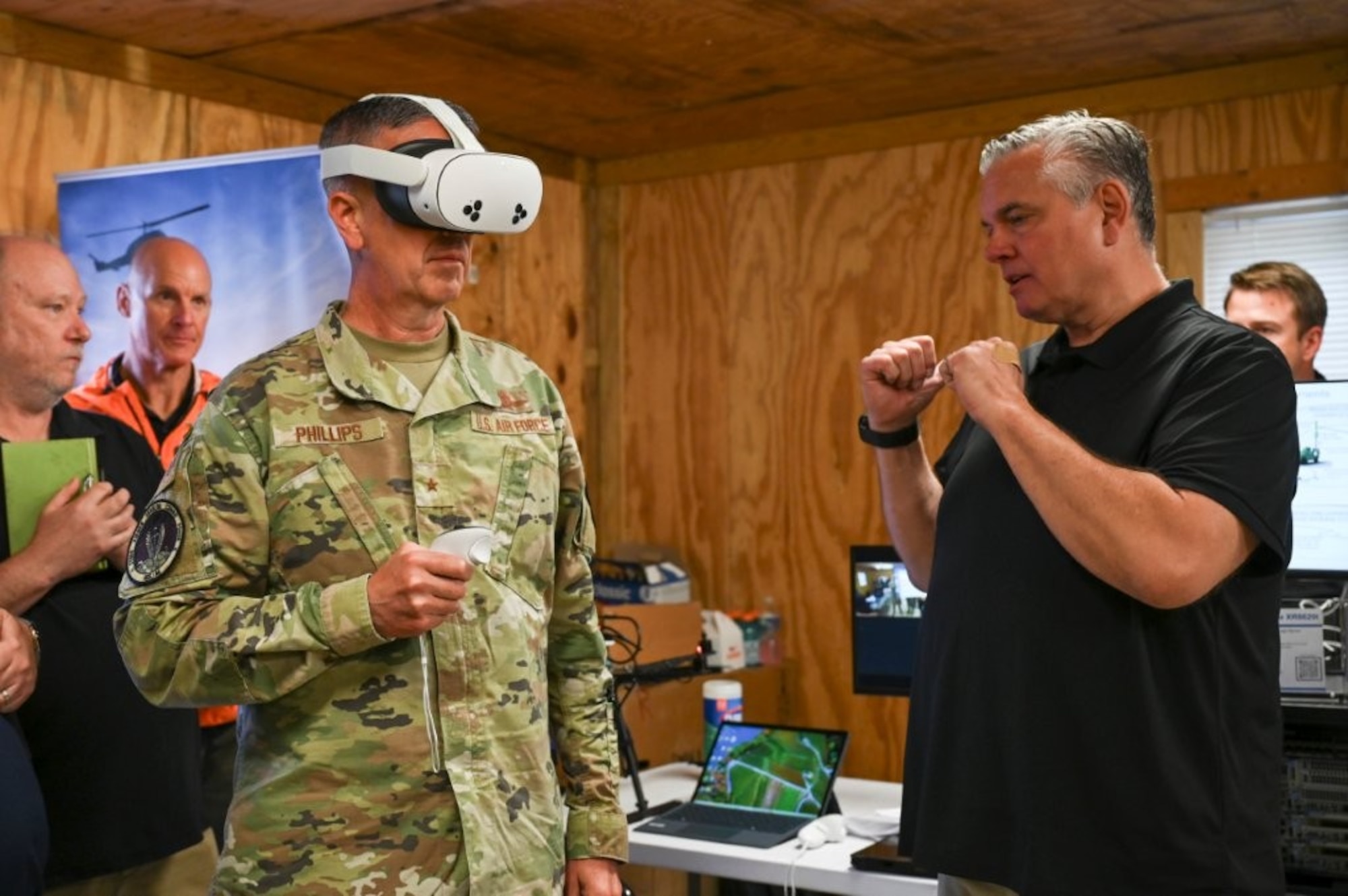 U.S. Air Force Brig. Gen. Jeffrey Phillips, left, Air Combat Command director of Cyberspace Operations and Warfighting Communications (ACC/A6), tries on a virtual reality headset during the Raptor Town Tactical Communications Demonstration at Joint Base Langley-Eustis, Virginia, May 7, 2026. Phillips was given demonstrations that highlight a broad spectrum of advanced deployable tactical communications technologies.