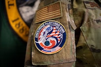 Senior Master Sgt. Naz Brockman, the State Partnership Program Senior Non-Commissioned Officer In Charge with the Washington Air National Guard, wears an Enduring Partners patch at Camp Murray, Wash., on June 1, 2026.