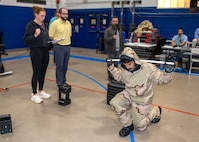 Sam Murphy, a doctoral candidate and Naval Research Enterprise Internship Program (NREIP) participant, observes, as Jenna Dufresne, NSWC PCD Personal Protective Equipment Branch scientist, records metrics while conducting kinetic testing on a sailor wearing individual protective equipment, July 22, 2025. This experiment aims to understand and mitigate the physiological burdens of protective gear used in chemical, biological, and radiological defense responses. (U.S. Navy by Ronnie Newsome)