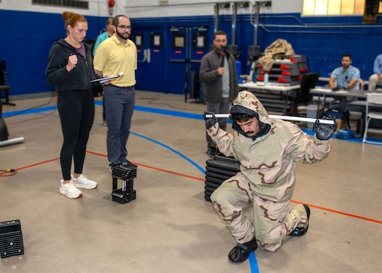 Sam Murphy, a doctoral candidate and Naval Research Enterprise Internship Program (NREIP) participant, observes, as Jenna Dufresne, NSWC PCD Personal Protective Equipment Branch scientist, records metrics while conducting kinetic testing on a sailor wearing individual protective equipment, July 22, 2025. This experiment aims to understand and mitigate the physiological burdens of protective gear used in chemical, biological, and radiological defense responses. (U.S. Navy by Ronnie Newsome)