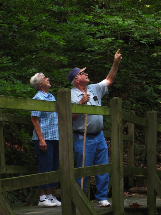 Couple hiking on a nature trail stops to view wildlife.