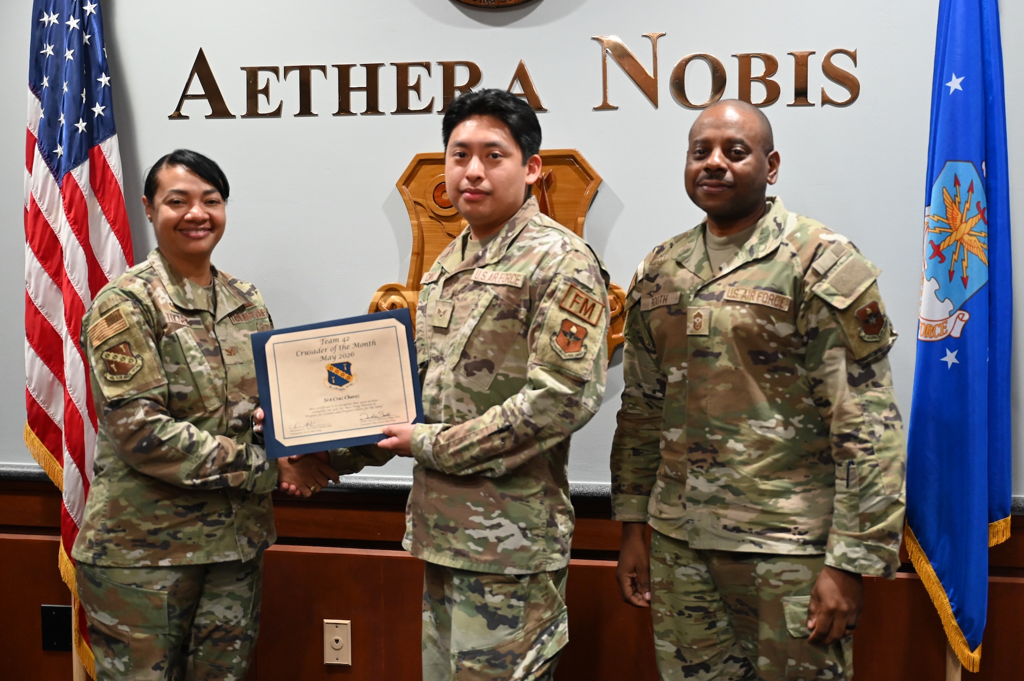 U.S. Air Force Senior Airman Cruz Chavez, 42d Comptroller Squadron financial operations technician, is presented a certificate recognizing him as the 42d Air Base Wing Crusader of the Month for May of 2026, by U.S. Air Force Colonel Shamekia Toliver, 42d ABW commander, May 27, 2026. The Crusader of the month program recognizes Airmen who demonstrate outstanding performance, leadership and dedication to the mission while embodying the Air Force core values of integrity first, service before self and excellence in all they do. (U.S. Air Force Photo by Eric Sharman)