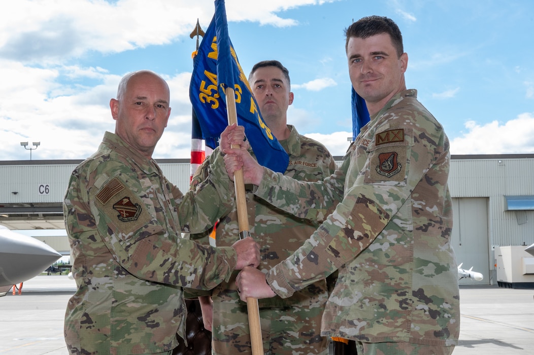 U.S. Air Force Col. Joseph Gilpin, left, 354th Maintenance Group commander, and Maj. Matthew Ward, outgoing 18th Fighter Generation Squadron commander, holds a guidon during the 354th Aircraft Maintenance Squadron activation ceremony on Eielson Air Force Base, Alaska, June 1, 2026.