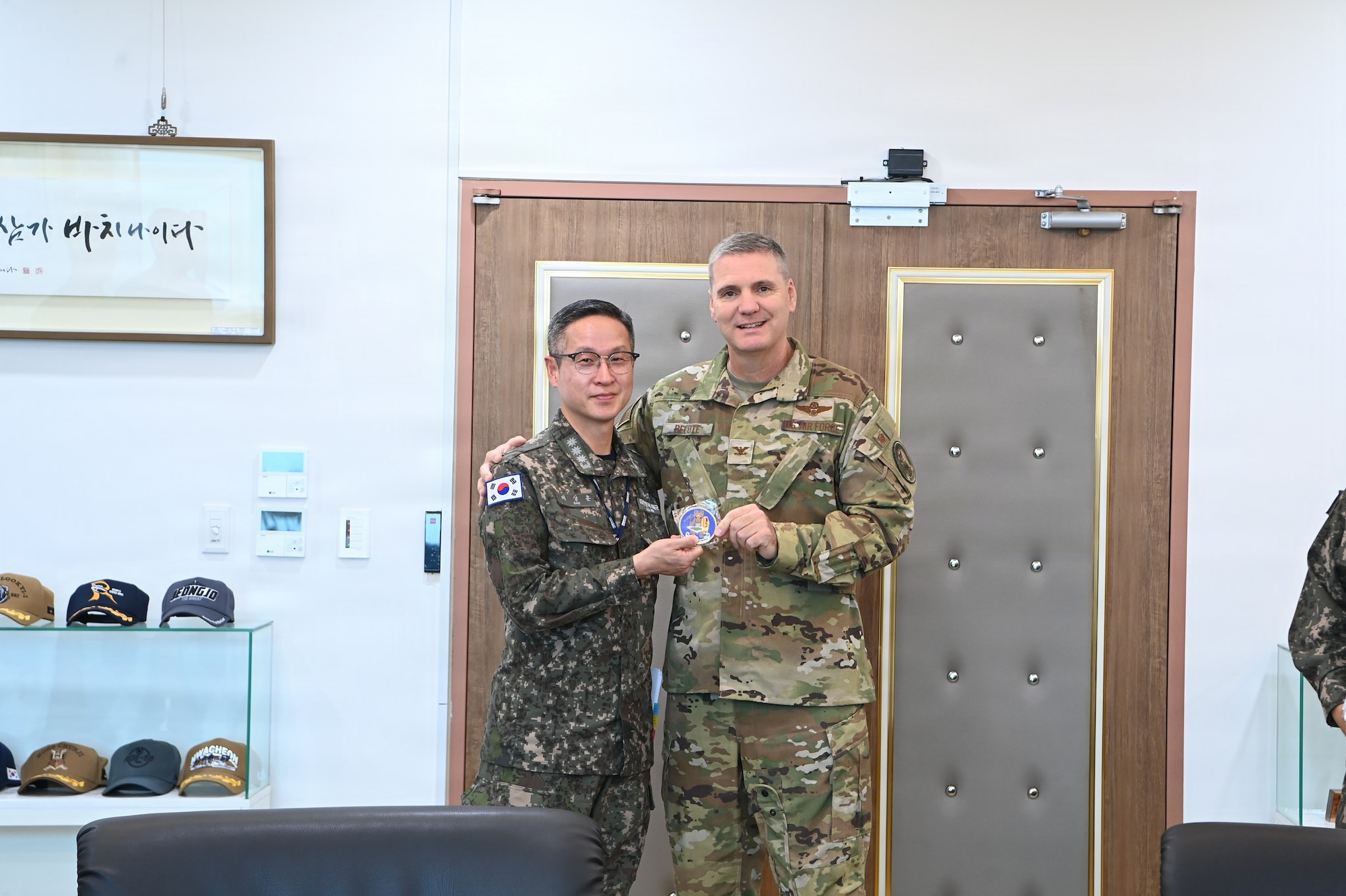 Photo of Col Belote presenting a military coin to his ROK Navy counterpart