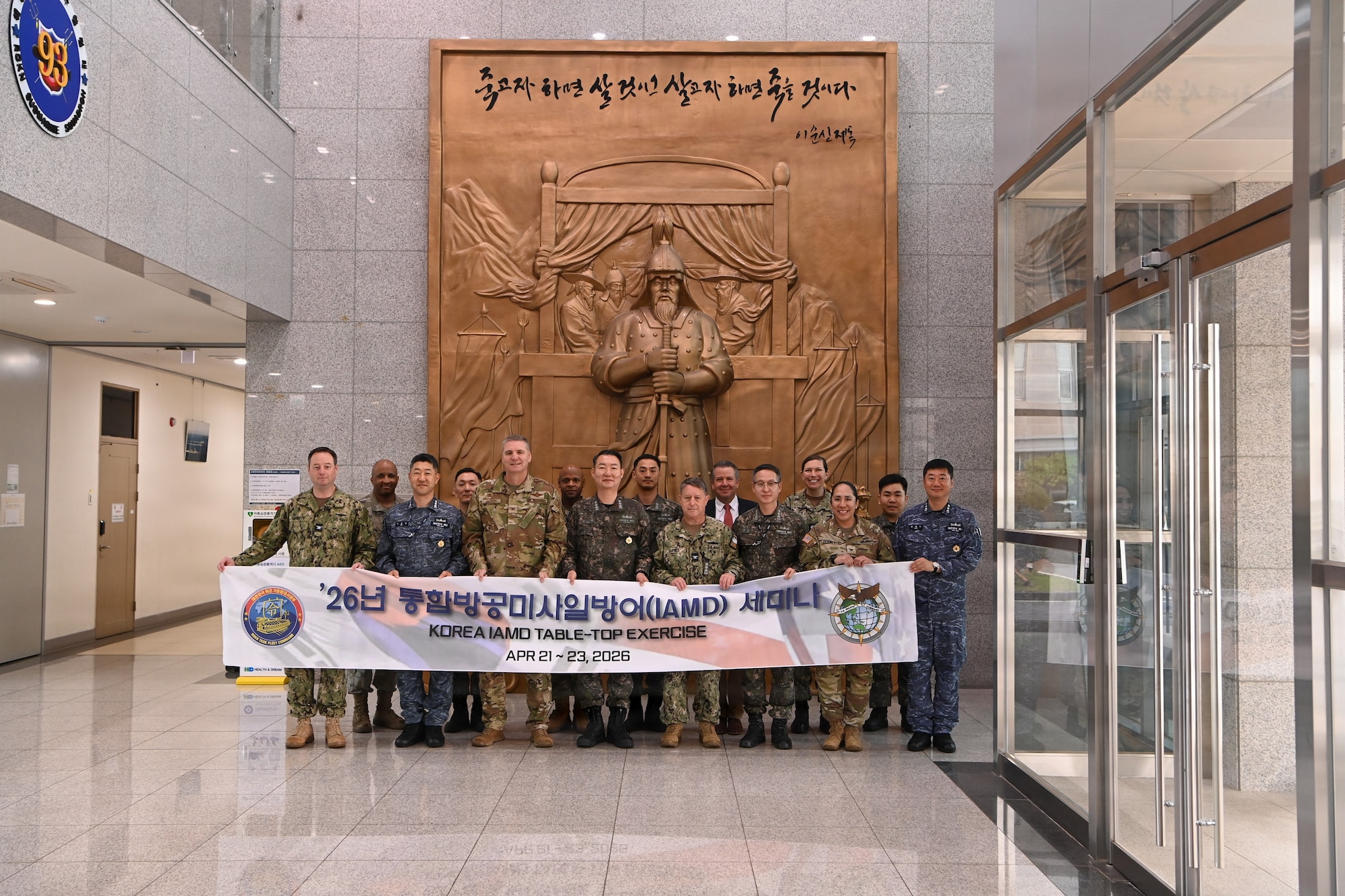 Group photo of US and ROK military members holding a banner