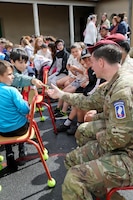 U.S. Soldiers with the 173rd Airborne Brigade exchange patches with school children during a musical exchange at the Ecole Primaire Les Hauts Champs in Carentan-les-Marais, France, June 2, 2026. The exchange highlights our shared values of free cultural expression while building a connection between U.S. service members and a new generation in Normandy. From June 2-7, 2026, more than 600 U.S. Soldiers, Sailors, Marines, Guardians and Airmen from roughly 17 units historically linked to D-Day made up Joint Task Force 82 and participated in over 90 commemorative events throughout the Normandy Region. (U.S. Army National Guard photo by 1st Sgt. HollyAnn Nicom)