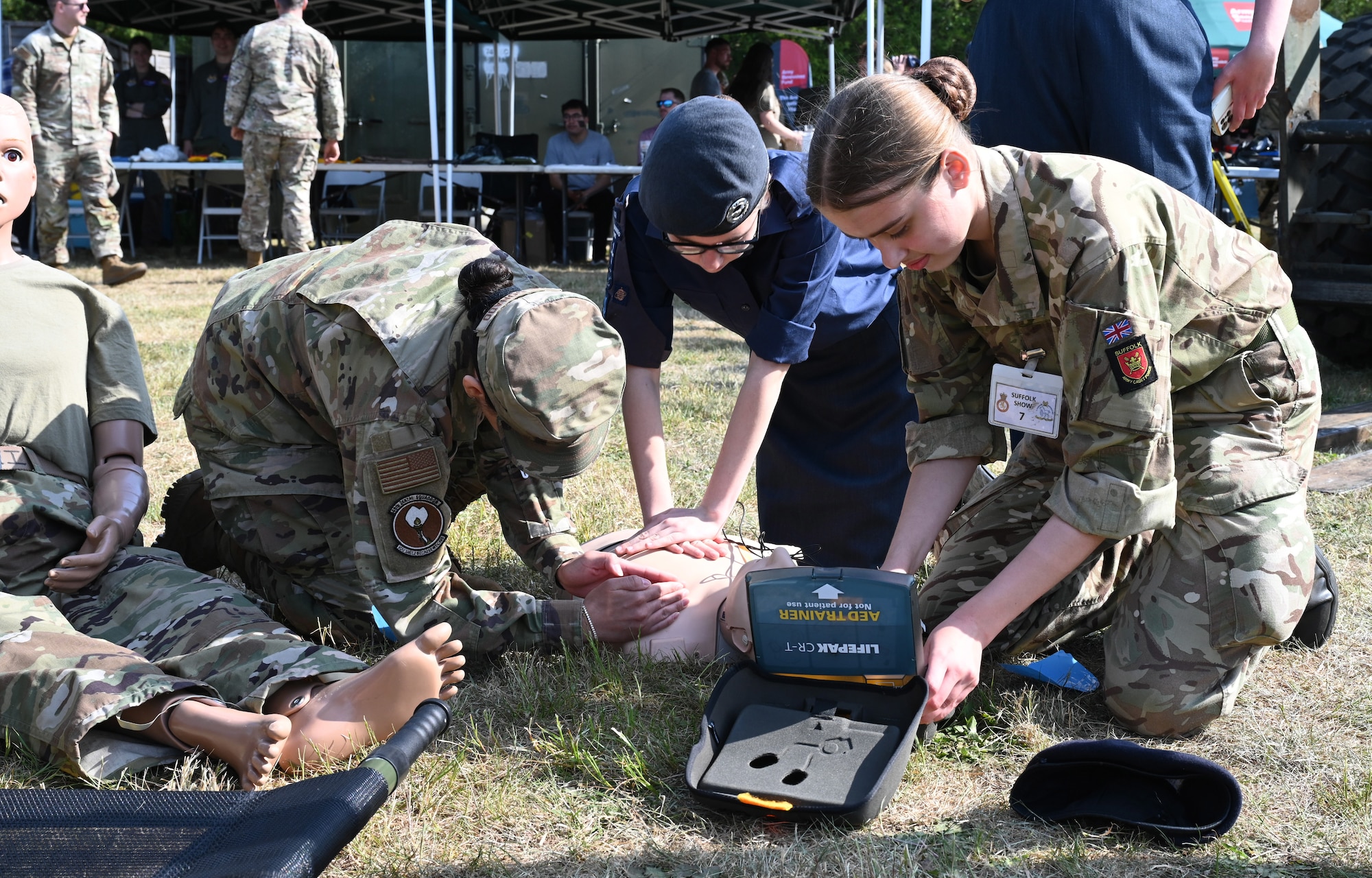 U.S. Air Force Senior Airman Honestee Maldonado, left, 48th Dental Squadron, RAF Lakenheath, shows British Army and Air Training Corps cadets how to perform CPR at the Suffolk Show in Ipswich, England, May 27, 2026.  Airmen from RAF Mildenhall and RAF Lakenheath spent two days at the Suffolk Show showcasing their equipment and capabilities. (U.S. Air Force photo by Karen Abeyasekere)