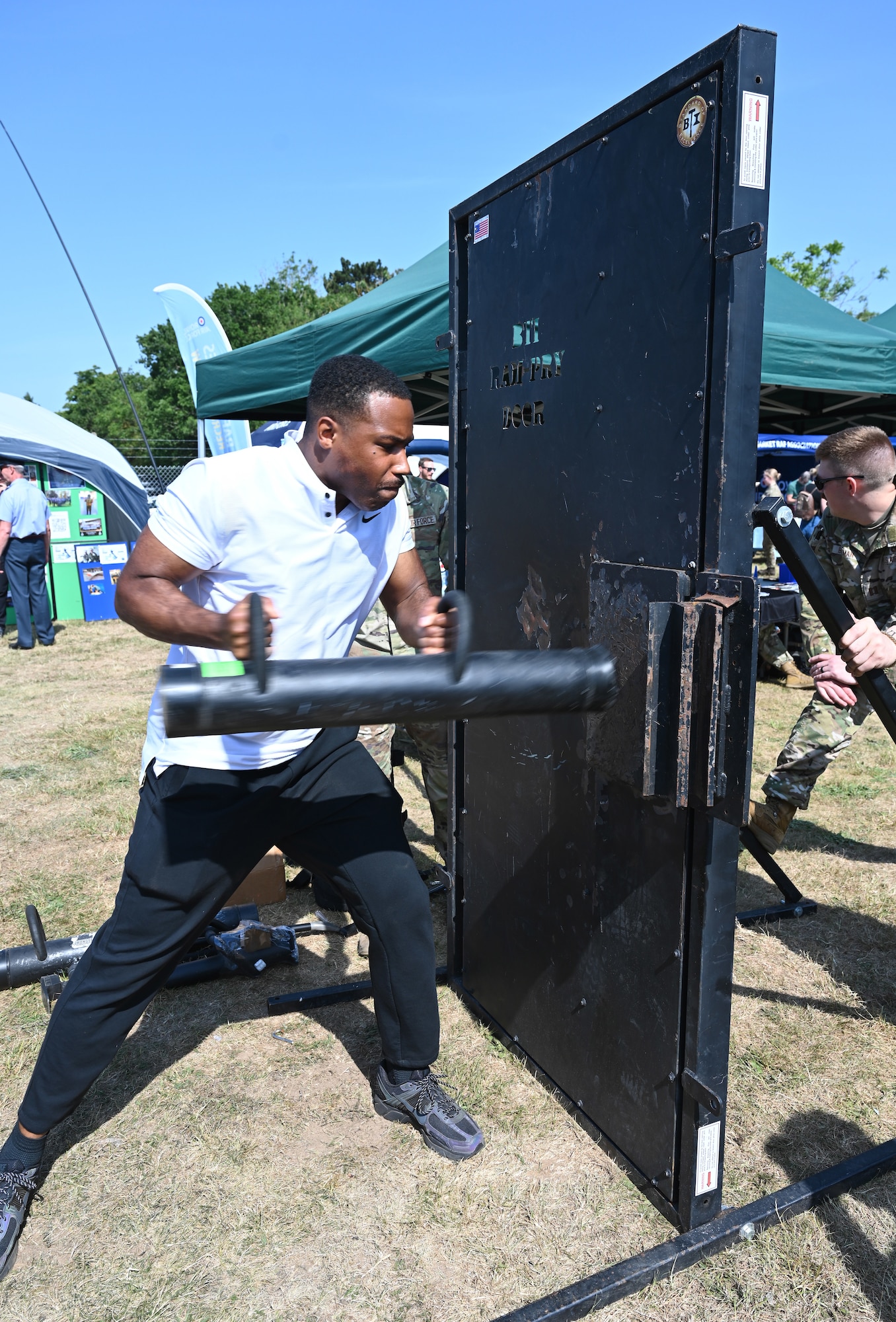 U.S. Air Force Airman Jehiel Azar, 100th Communications Squadron cyber transport technician, uses a battering ram to forcibly open a breacher door as part of a demonstration of equipment from the 100th Security Forces Squadron at the Suffolk Show in Ipswich, England, May 27, 2026. Airmen from RAF Mildenhall and RAF Lakenheath spent two days at the Suffolk Show showcasing their equipment and capabilities and were joined by British military and cadet forces in the “Military Zone” area of the event. (U.S. Air Force photo by Karen Abeyasekere)