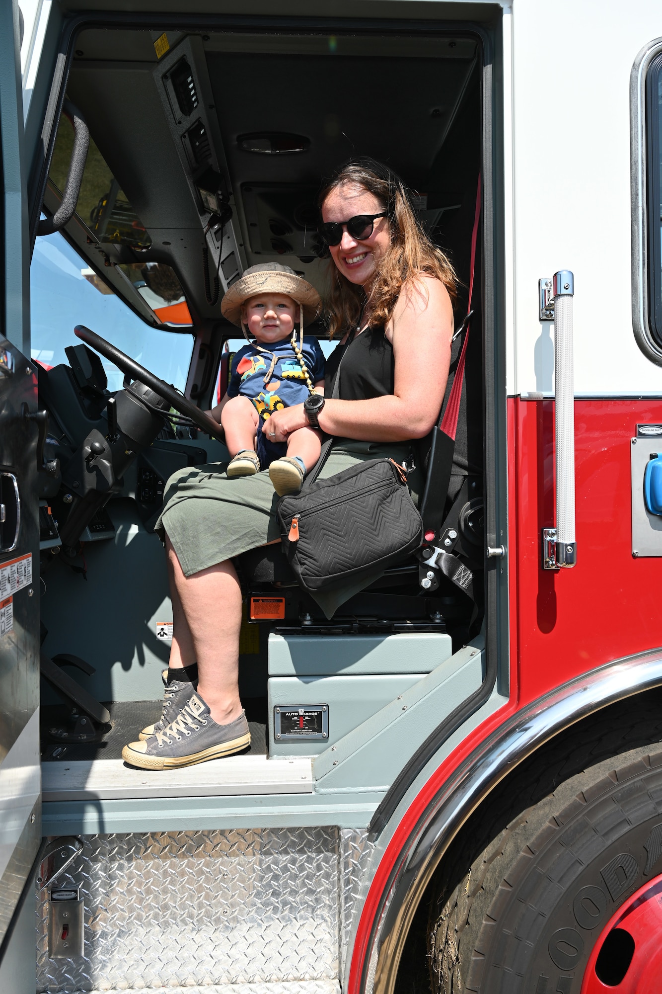 Grayling Goodall holds her son Gwilym, as they look inside a U.S. Air Force fire truck at the Suffolk Show in Ipswich, England, May 27, 2026.  Airmen from RAF Mildenhall and RAF Lakenheath spent two days at the Suffolk Show showcasing their equipment and capabilities, and were joined by British military and cadet forces in the “Military Zone” area of the event. (U.S. Air Force photo by Karen Abeyasekere)