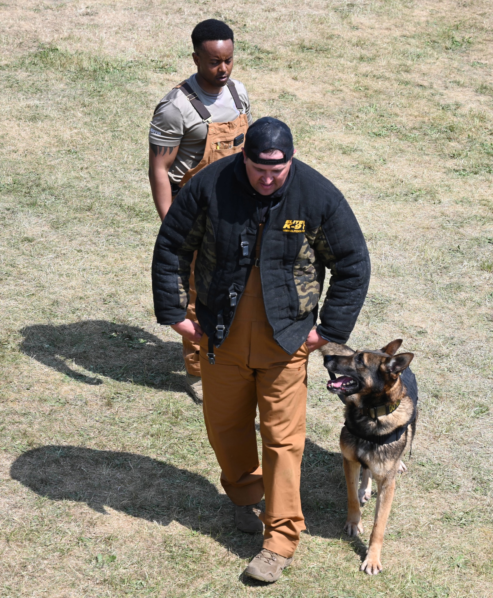 U.S. Air Force Military Working Dog Juan keeps a watchful eye on Staff Sgt. Charles Pope, 100th Security Forces Military Working Dog section kennel master, during a demonstration of the military K-9’s capabilities at the Suffolk Show in Ipswich, England, May 27, 2026. Juan, along with his handler and kennel master, performed two demonstrations during the first day of the event. (U.S. Air Force photo by Karen Abeyasekere)