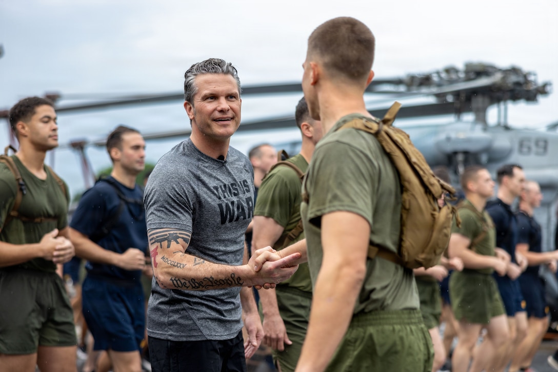Secretary of War Pete Hegseth greets a U.S. Marine with the 11th Marine Expeditionary Unit during a physical training event aboard Wasp-class amphibious assault ship USS Boxer (LHD 4) in Singapore, May 29, 2026. The 11th MEU, embarked aboard the Boxer Amphibious Ready Group, is a persistent, combat credible force contributing to deterrence and crisis response in the U.S. 7th Fleet area of operations. U.S. 7th Fleet, the U.S. Navy's largest forward-deployed numbered fleet, routinely interacts and operates with allies and partners to preserve a free and open Indo-Pacific. (U.S. Marine Corps photo by Sgt. Trent A. Henry)