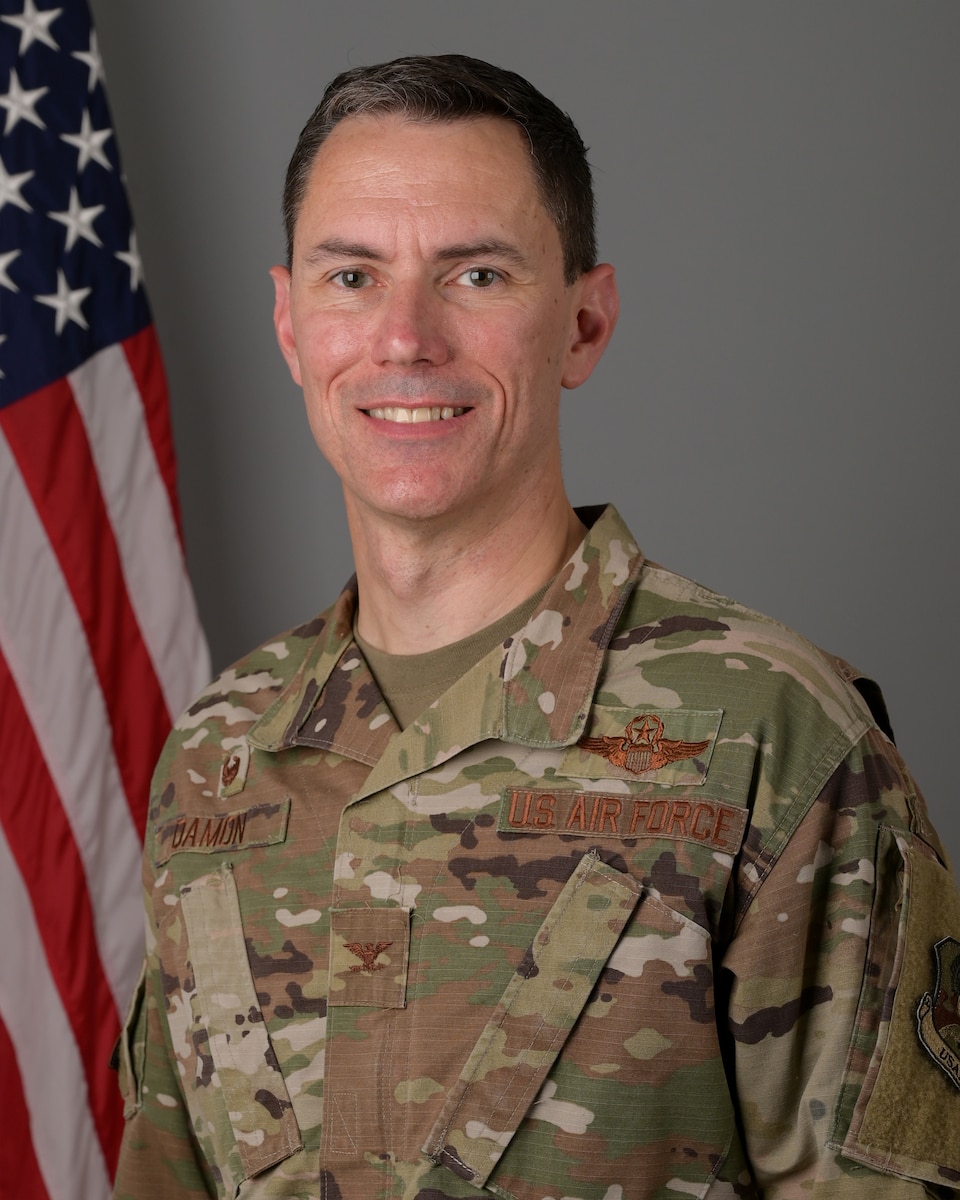 Official photo of Col. Cory Damon with American flag in the background