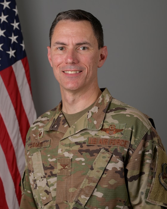 Official photo of Col. Cory Damon with American flag in the background
