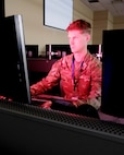 Alt text: uniformed U.S. Airman works at a computer