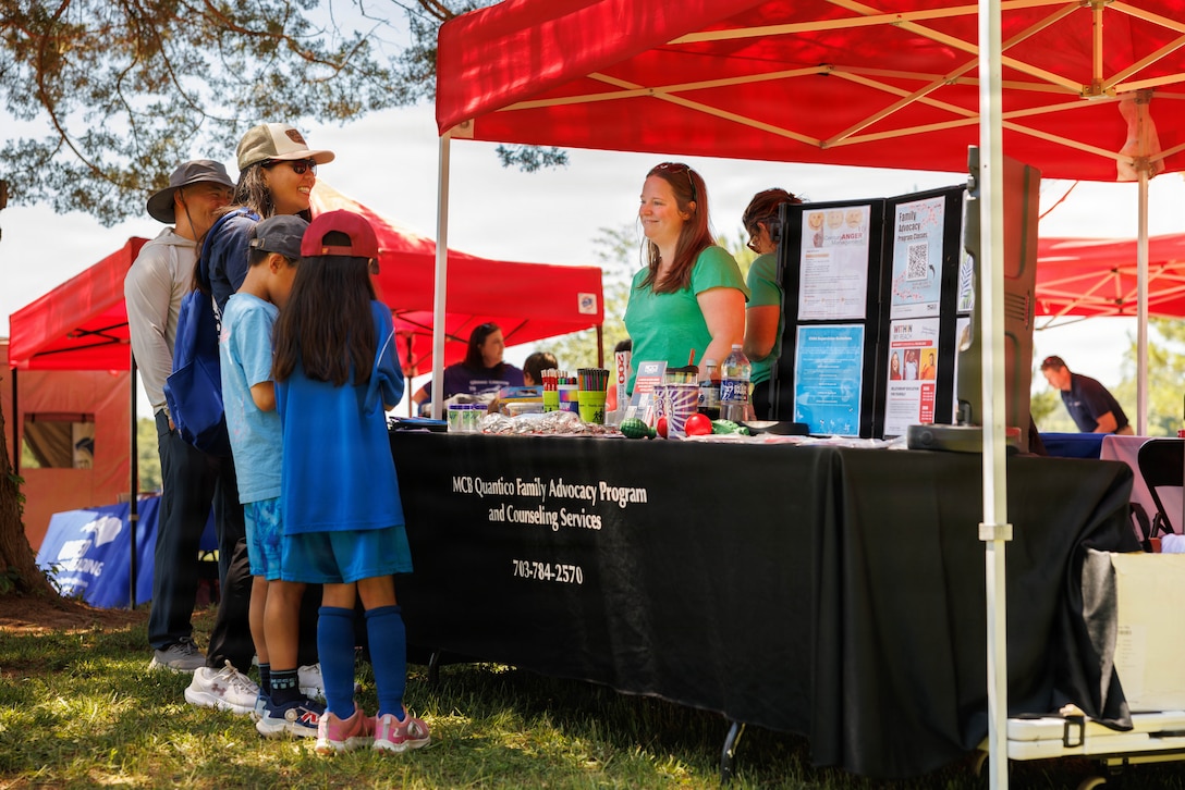 Sesalle McDaniel, a prevention and education specialist with the Family Advocacy Program, speaks to families during the Exceptional Family Member Program Rolling into Summer event at Lunga Park on Marine Corps Base Quantico, Virginia, May 30, 2026. Rolling into Summer is an event held with community partners with a focus on fun, safety, and community. During the event, families enjoyed crafts, sports relays, and opportunities to learn about base resources while building their local network and speaking with base leadership and EFMP Family Caseworkers. (U.S. Marine Corps photo by Cpl. Harleigh Faulk)