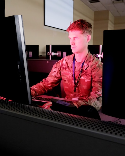 Alt text: uniformed U.S. Airman works at a computer