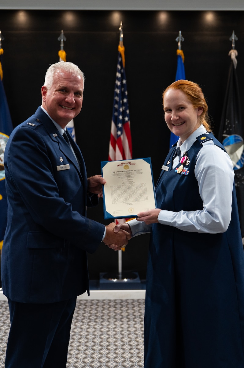 U.S. Air Force Col. Matthew Norton, 17th Training Wing commander, presents Maj. Kelly Griffith, outgoing 17th Comptroller Squadron commander, with the Meritorious Service Medal certificate during a change of command ceremony at Goodfellow Air Force Base, Texas, June 2, 2026. Griffith was awarded the Meritorious Service Medal for distinguishing herself through outstanding achievements and service to the United States. (U.S. Air Force photo by Senior Airman Brian Lummus)