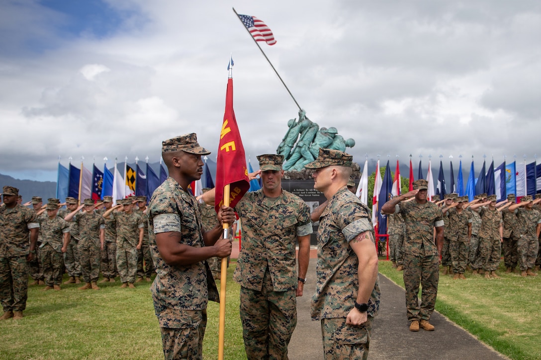 U.S. Marine Corps Capt. Darnell Burton, left, the oncoming commander, receives a guidon from Maj. Christian Friend, the outgoing commander of Ground-Based Air Defense Battery, 3rd Littoral Anti-Air Battalion, 3rd Marine Littoral Regiment, 3rd Marine Division at Marine Corps Base Hawaii, May 29, 2026. The change of command ceremony symbolizes the official handover of duties and authority as battery commander. Capt. Burton is from Maryland, and Maj. Friend is from Texas. (U.S. Marine Corps photo by Lance Cpl. Matthew Benfield)