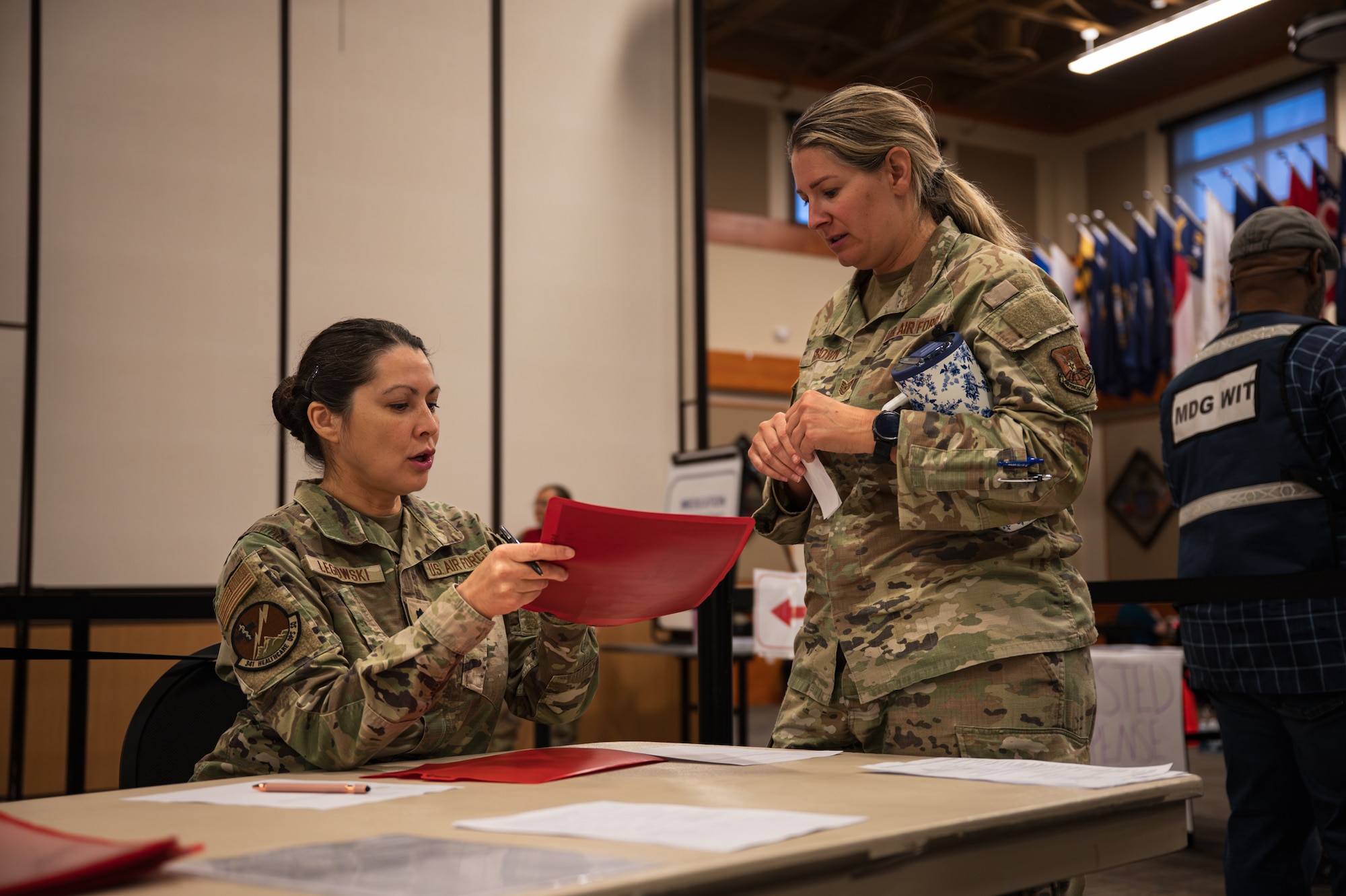 Two uniformed women have a conversation.