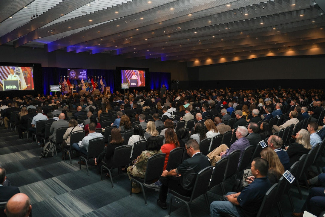 A large group of people are seated in an auditorium.
