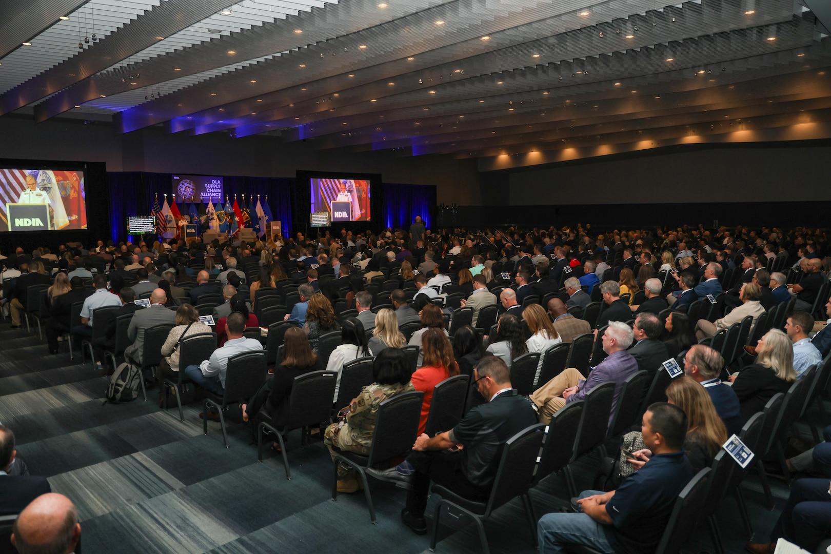 A large group of people are seated in an auditorium.