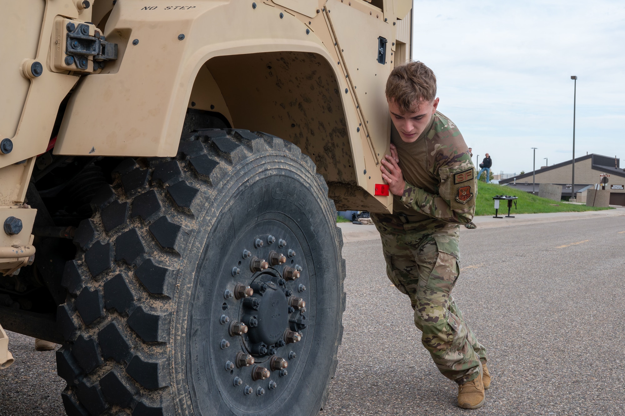 U.S. Air Force Defender pushes a JLTV truck.