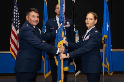 Air Force commander, passes the 37th Training Wing guidon to Col. Kellie S. Courtland, 37th TRW incoming commander, during the 37th TRW change of command ceremony at Joint Base San Antonio-Lackland, Texas, May 29, 2026. The change of command ceremony is a military tradition that allows unit members to see the outgoing commander depart and identify the incoming commander. (U.S. Air Force photo by Marcus Robins)