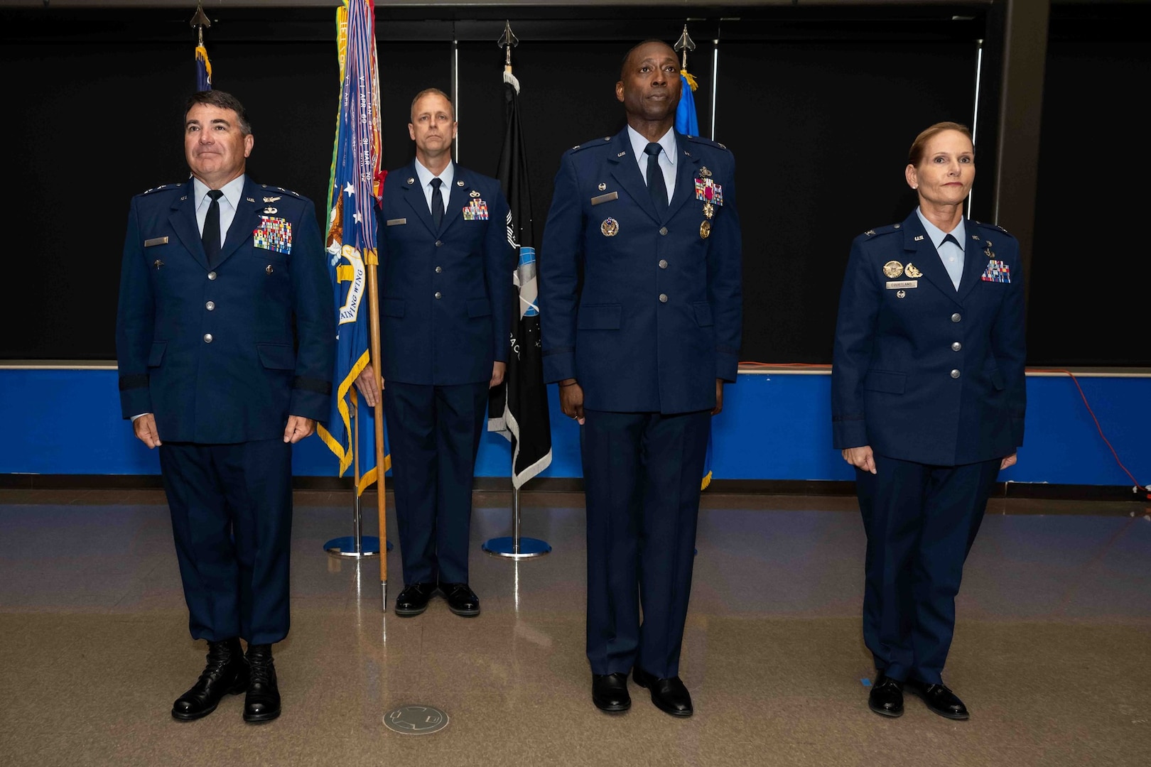 U.S. Air Force Maj. Gen. Wolfe Davidson, Second Air Force commander, left; Col. Willie L. Cooper, 37th Training Wing outgoing commander; and Col. Kellie S. Courtland, 37th TRW incoming commander, stand at attention on stage prior to the passing of the guidon during the 37th TRW change of command ceremony at Joint Base San Antonio-Lackland, Texas, May 29, 2026. The change of command ceremony is a military tradition that allows unit members to see the outgoing commander depart and identify the incoming commander. (U.S. Air Force photo by Marcus Robins)