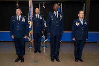 U.S. Air Force Maj. Gen. Wolfe Davidson, Second Air Force commander, left; Col. Willie L. Cooper, 37th Training Wing outgoing commander; and Col. Kellie S. Courtland, 37th TRW incoming commander, stand at attention on stage prior to the passing of the guidon during the 37th TRW change of command ceremony at Joint Base San Antonio-Lackland, Texas, May 29, 2026. The change of command ceremony is a military tradition that allows unit members to see the outgoing commander depart and identify the incoming commander. (U.S. Air Force photo by Marcus Robins)