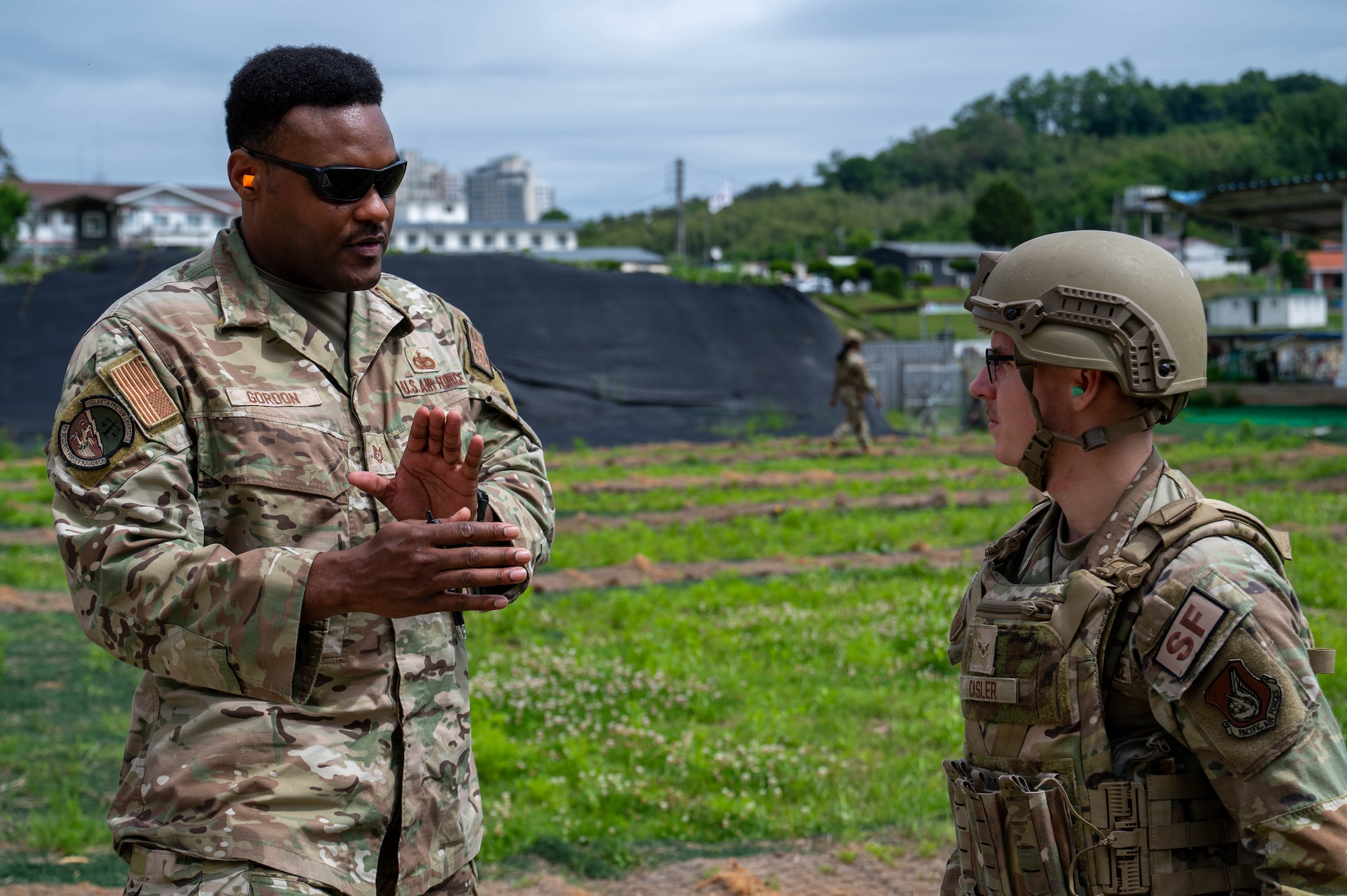 U.S. Air Force Tech. Sgt. Shelby Gordon, 8th Security Forces Squadron defender weapons trainer, left, provides feedback during the defender weapon trainer class at a Republic of Korea Army shooting range, ROK, May 27, 2026. The defender weapon trainer course is a two-day course, pairing class-room instruction with live-fire qualification. (U.S. Air Force photo by Staff Sgt. Cedrique Oldaker)