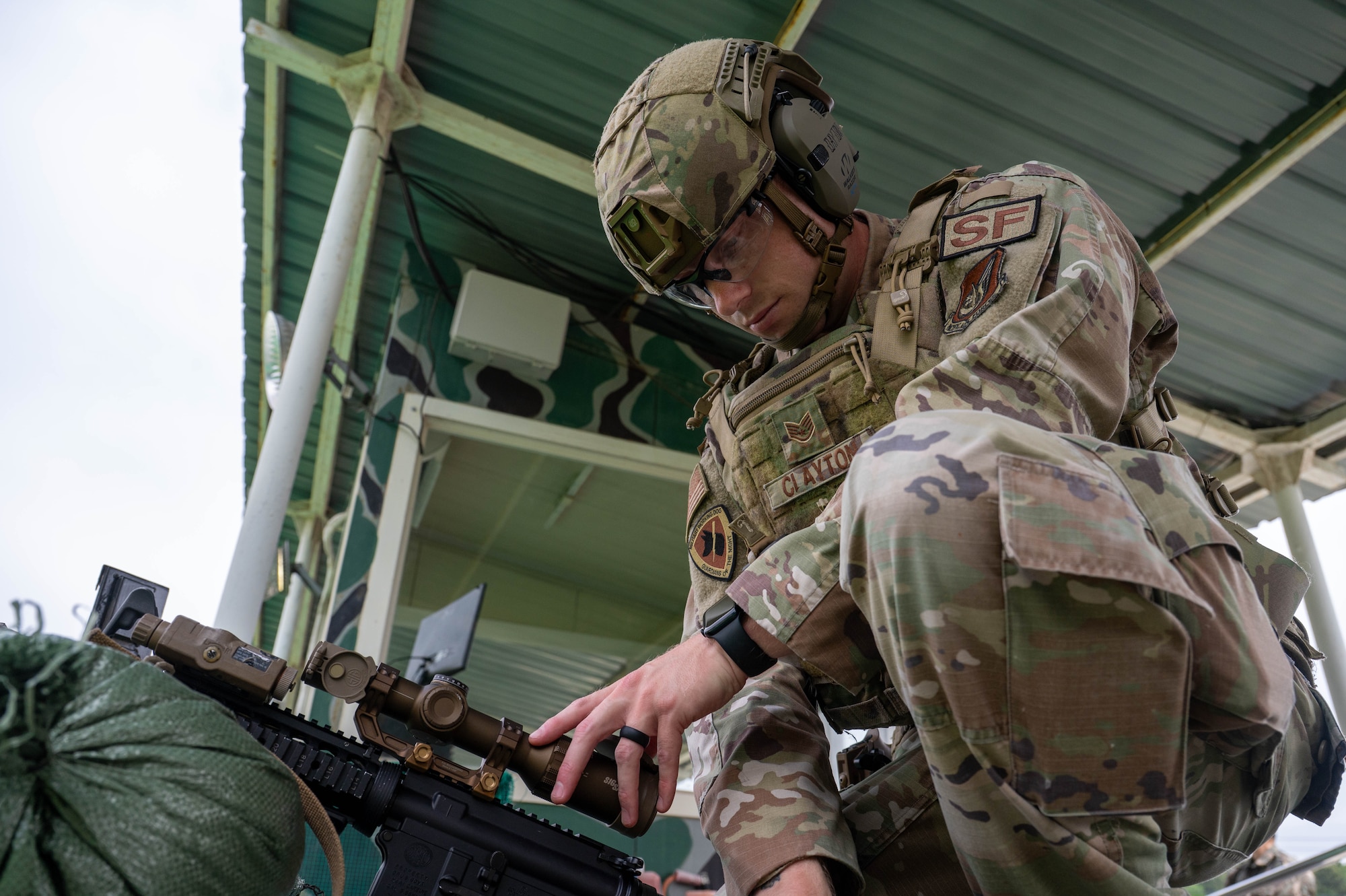 U.S. Air Force Tech. Sgt. Damien Clayton, 8th Security Forces Squadron military working dog trainer, adjusts the optics on his weapon during the defender weapon trainer class at a Republic of Korea Army shooting range, ROK, May 27, 2026. The course is designed to decentralize training authority, dispersing instructor capabilities across the entire squadron rather than concentrating it solely within a specialized flight. (U.S. Air Force photo by Staff Sgt. Cedrique Oldaker)