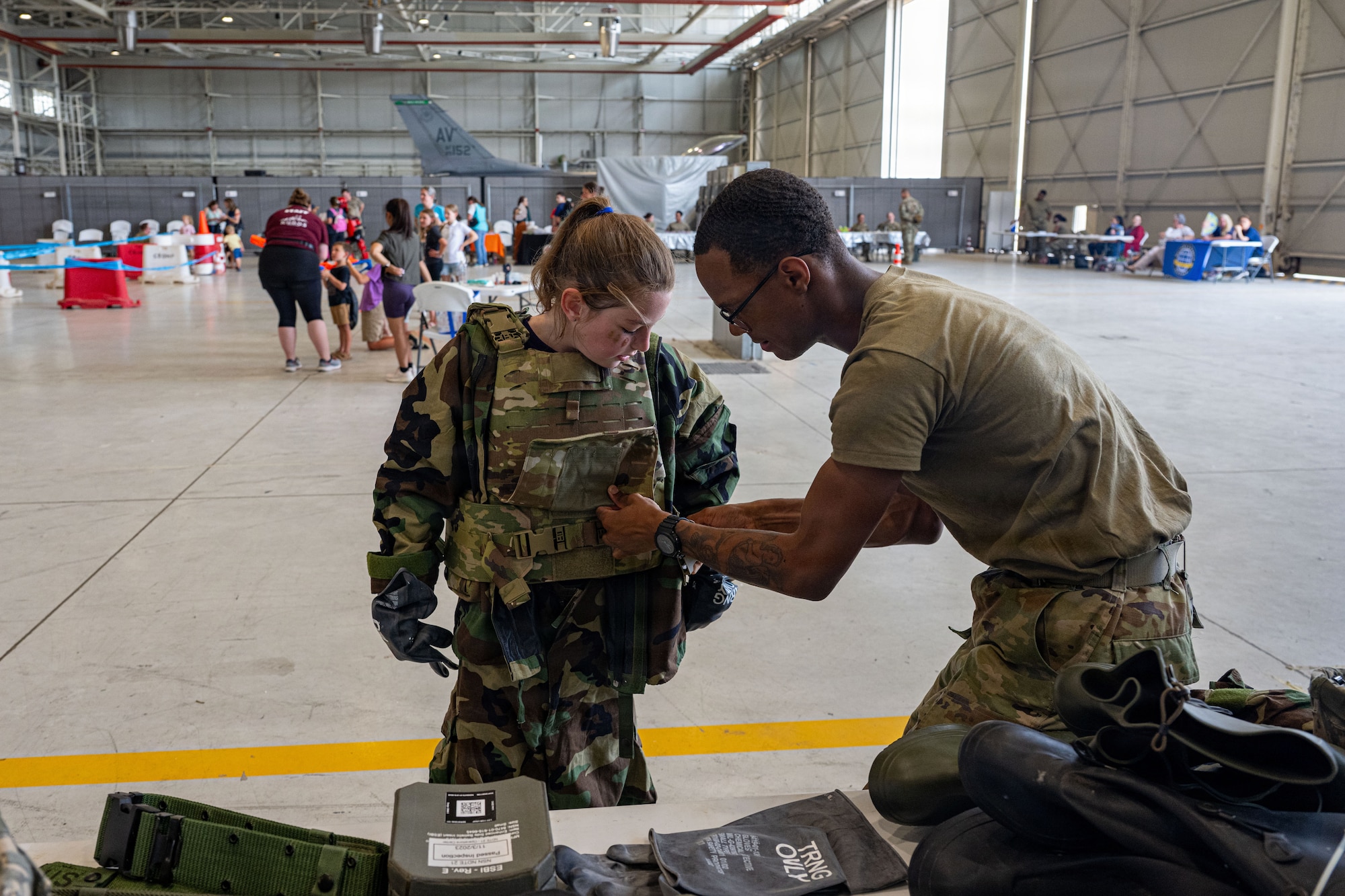 A man helps a child put on a bulletproof vest