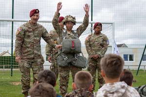 U.S. paratroopers assigned to the Light Support Battalion, 173rd Airborne Brigade, orient students from Picauville Elementary School to a parachute during a D-Day 82 exchange at Picauville, France, June 2, 2026. The 173rd Airborne Brigade joined representatives from the Golden Knights and the Round Canopy Parachute Team to orient French school children to paratrooper equipment. (U.S. Army photo by Maj. Joe Legros)