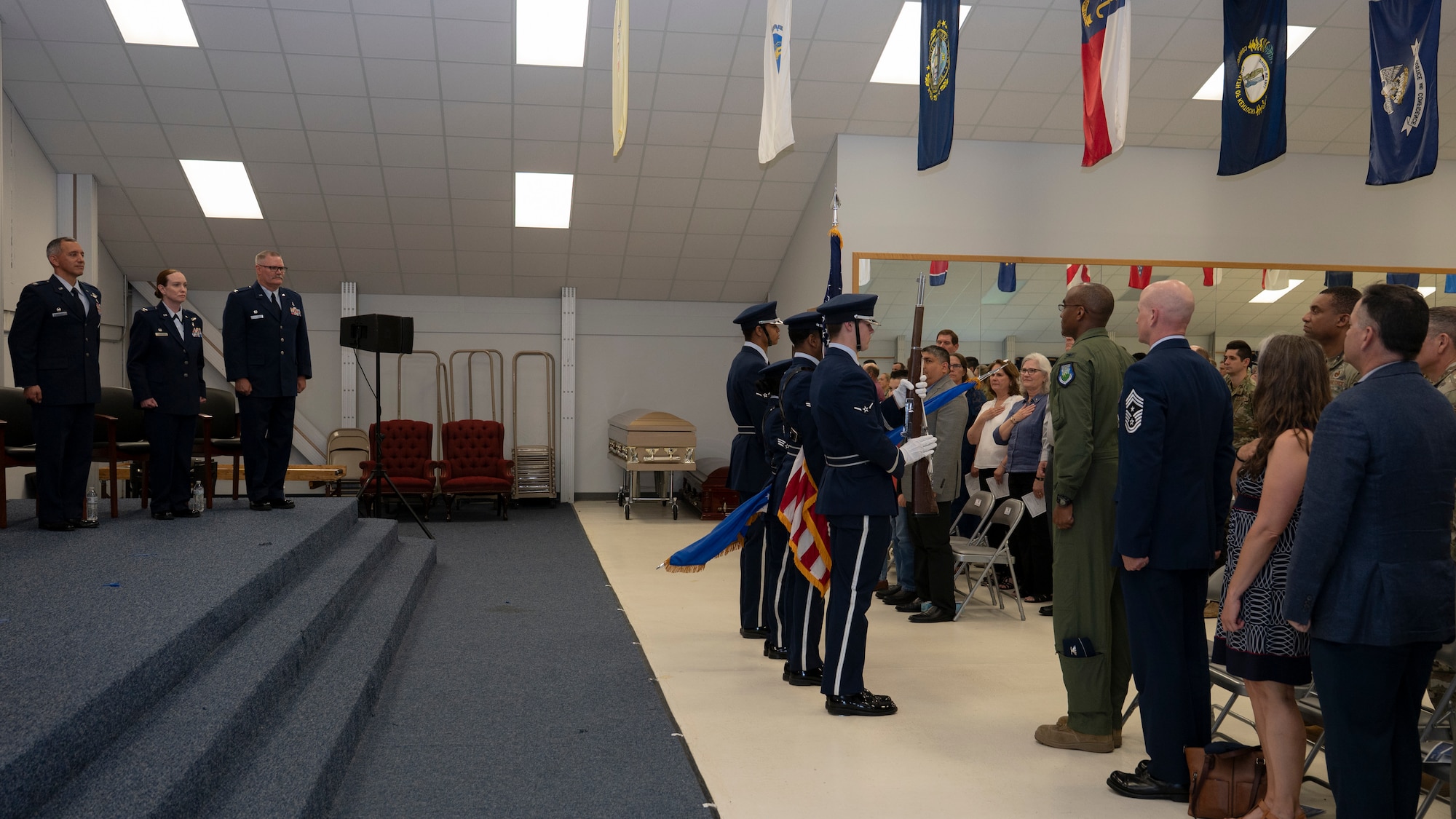 Crowd shows respect to honor guard.
