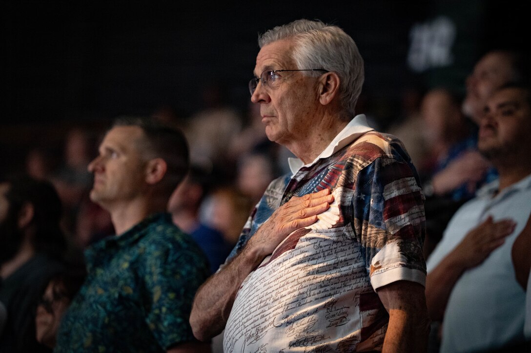 An audience member places his hand over his heart during the National Anthem at the Virginia International Tattoo at Scope Arena in Norfolk, Virginia, April 17, 2026. The annual event showcases military bands and ceremonial units from around the world, highlighting tradition, precision and international partnership. (U.S. Army photos by Sgt. Samantha Cate)