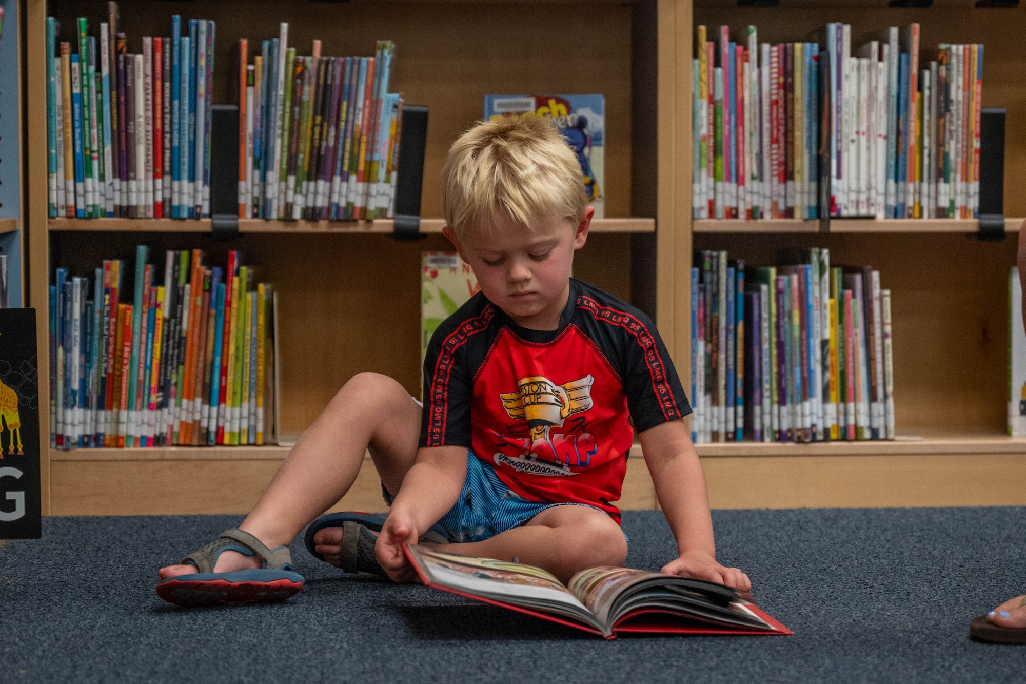 A military child reads a book during the 56th Force Support Squadron’s Luke Air Force Base Library "Plant a Seed, Read" summer reading program kickoff at Luke Air Force Base, Arizona, June 3, 2026.