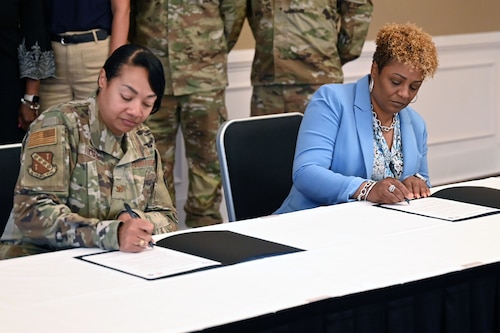 U.S. Air Force Col. Shamekia Toliver, 42d Air Base Wing commander, and Dr. Kemba Chambers, president of Trenholm State Community College, sign an Intergovernmental Support Agreement at the Maxwell Event Center on Maxwell Air Force Base, Alabama, June 3, 2026. This collaboration creates a potential pipeline of talented childcare professionals for Maxwell and Gunter’s programs. (U.S. Air Force Photo by Eric Sharman)