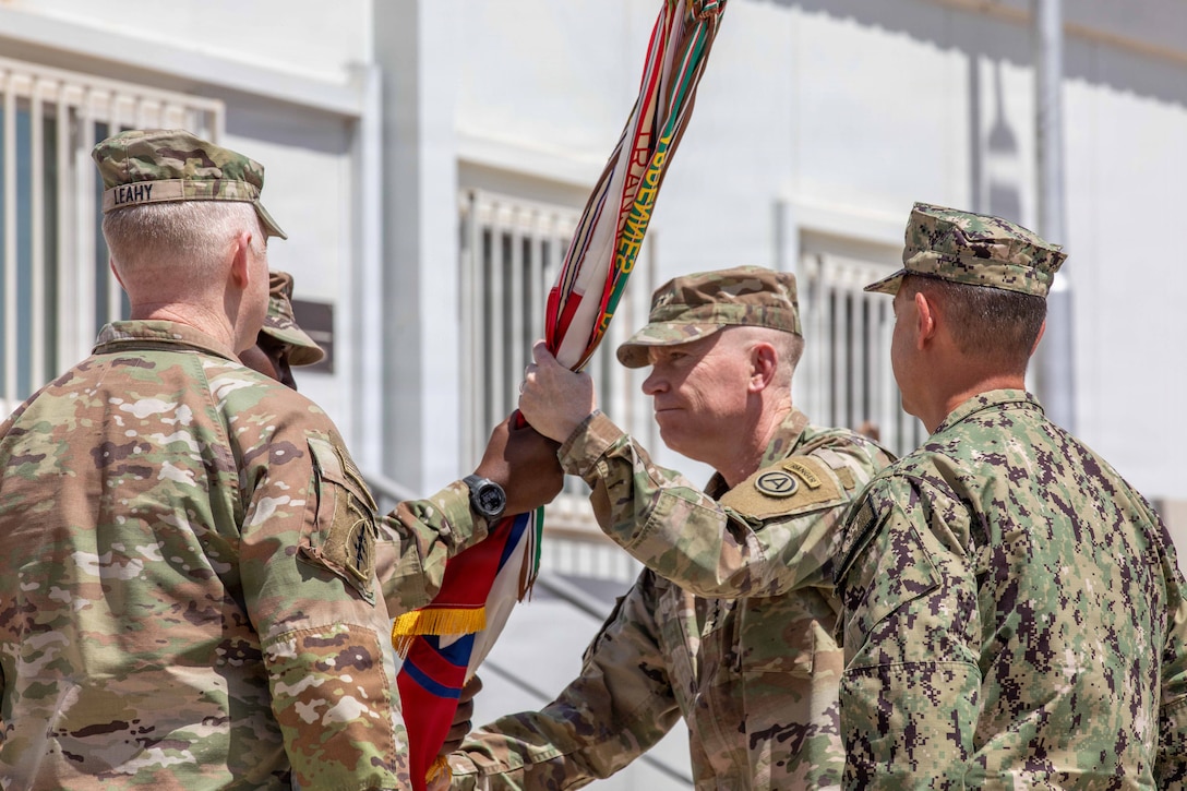 Lt. Gen. Patrick Frank (center), outgoing commander of U.S. Army Central (ARCENT) and Third Army, receives the ARCENT colors from Command Sgt. Maj. Eric McCray, ARCENT senior enlisted advisor, during the ARCENT change of command ceremony June 4 in the Middle East. (U.S. Army photo)