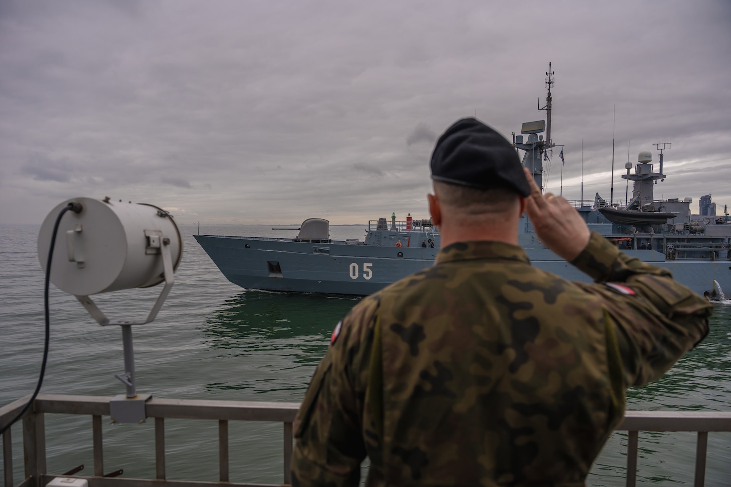 A Polish Army Solider salutes the Finnish Navy's Hämeenmaa-class minelayer FNS Uusimaa (05) as it departs the port of Gdynia, Poland, to participate in exercise Baltic Operations (BALTOPS) 2026 June 4, 2026.