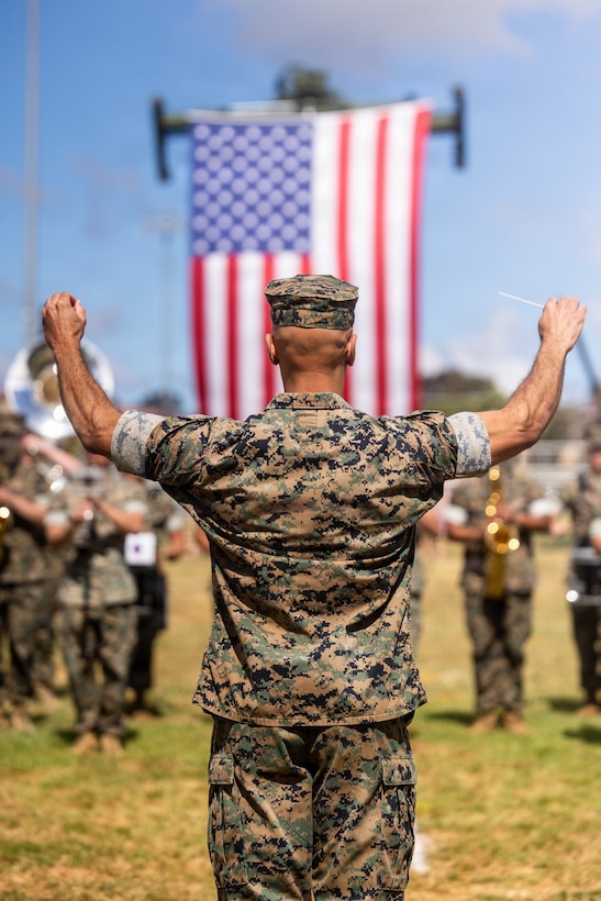U.S. Marine Corps Capt. Eric Kyne, the officer in charge of the 1st Marine Division band, conducts the band during the 1st MARDIV change of command ceremony at Marine Corps Base Camp Pendleton, California, May 29, 2026. During the ceremony, Thomas B. Savage relinquished command of the division to Brig. Gen. Andrew T. Priddy. Kyne is a native of Connecticut. (U.S. Marine Corps photo by Sgt. Vincent Needham)