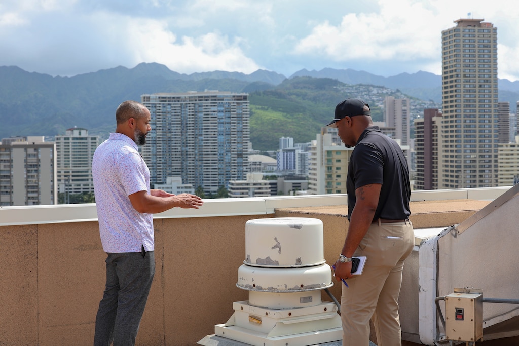 Xavier Thigpen, Huntsville Center project manager, and Jason Bolling, Hale Koa Hotel director of engineering, are photographed speaking about maintenance for the rooftop equipment.