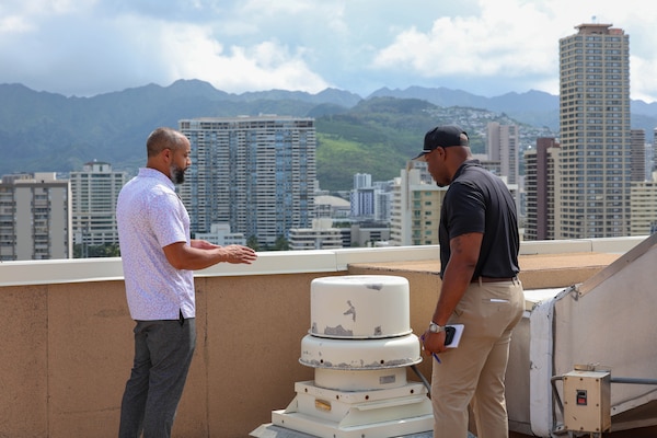 Xavier Thigpen, Huntsville Center project manager, and Jason Bolling, Hale Koa Hotel director of engineering, are photographed speaking about maintenance for the rooftop equipment.