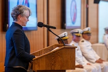 A photo of a woman delivering a speech.