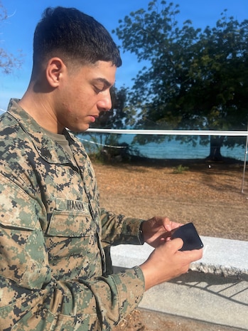 U.S. Marine Corps Sgt. Christian Hanna, a data systems administrator assigned to15th Marine Expeditionary Unit, I Marine Expeditionary Force, reviews tactical data on a cell phone running the Tactical Assault/Team Awareness Kit (TAK) outside the Exercise Cobra Gold 2026 Combined Joint Force Maritime Coordination Center, Royal Thai Marine Corps Base Camp Jessada, Chonburi, Thailand, March 2, 2026.