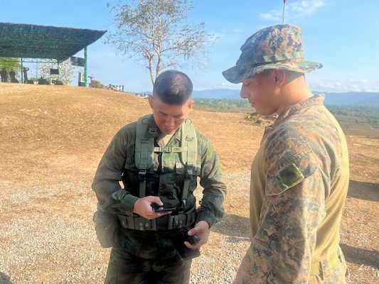 Royal Thai Marine Corps Division LT. j.g.Nuttachid Tuntha and U.S. Marine Corps Sgt. Christian Hannah, assigned to15th Marine Expeditionary Unit, I Marine Expeditionary Force, read data on a Tactical Assault/Team Awareness kit at the combined arms live-fire exercise during Exercise Cobra Gold 2026, in Ban Chan Khrem, Chanthaburi province, Thailand, March 6, 2026.