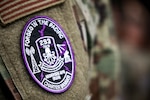 A charter member of the 293rd Combat Communications Squadron, Guam Air National Guard, displays the unit patch after passing an Initial Operating Capability (IOC) inspection, Guam, June 4, 2026. The first new squadron of the Guam Air National Guard in over 25 years, the squadron underwent a rigorous inspection that tested its ability to rapidly set up and operate critical communication equipment in the field and highlighted the growing need for strong, reliable communications in the Indo-Pacific region. Photo by Mark Scott.