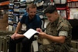 Two gentlemen look at an inventory sheet