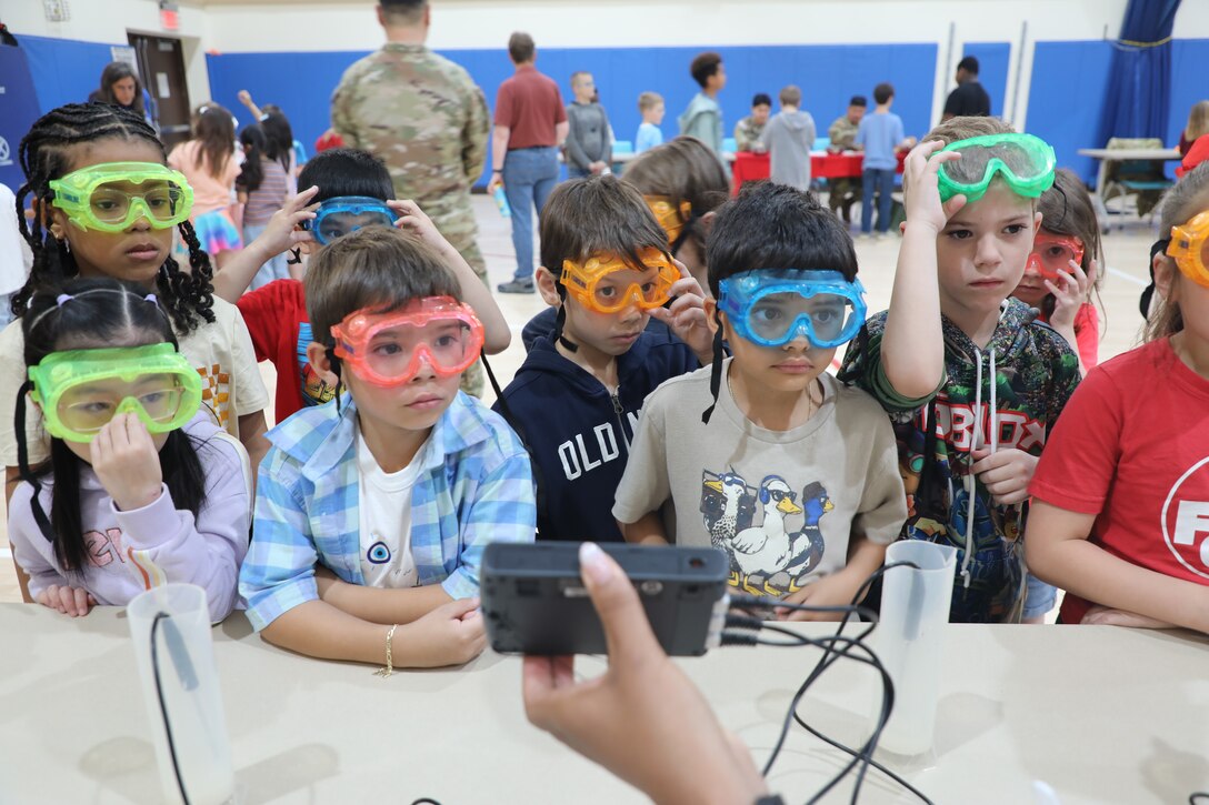 Students wearing safety goggles attentively observe a STEAM demonstration during an outreach event hosted by the U.S. Army Corps of Engineers – Far East District at Osan Elementary School, Osan Air Base, South Korea, May 21, 2026. Through demonstrations and hands-on learning experiences, students explored concepts designed to strengthen critical thinking, problem-solving and creativity. (U.S. Army photo by Yohan An)